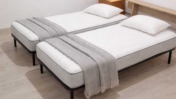 A double bed with a grey blanket, a bedside table with a lamp, and a wooden headboard. - A retreat in the baroque heart of Ragusa Ibla (Ragusa)