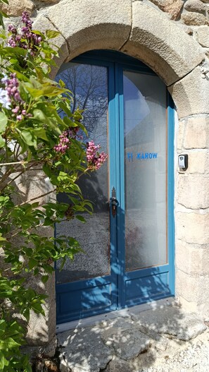 A blue door with the inscription 'TI KAROW' and a stone archway. - Country house with fireplace, right next to trails. Pets welcome! (Mégrit)