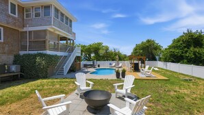 A backyard with a swimming pool, outdoor seating, and a covered area. - Walk to Beach | Sunset Views! Pool | Hot Tub| Duck (Duck)
