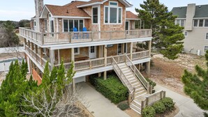 A multi-story house with a balcony, a staircase, and a sign that reads 'Baywatch.' - Walk to Beach | Sunset Views! Pool | Hot Tub| Duck (Duck)
