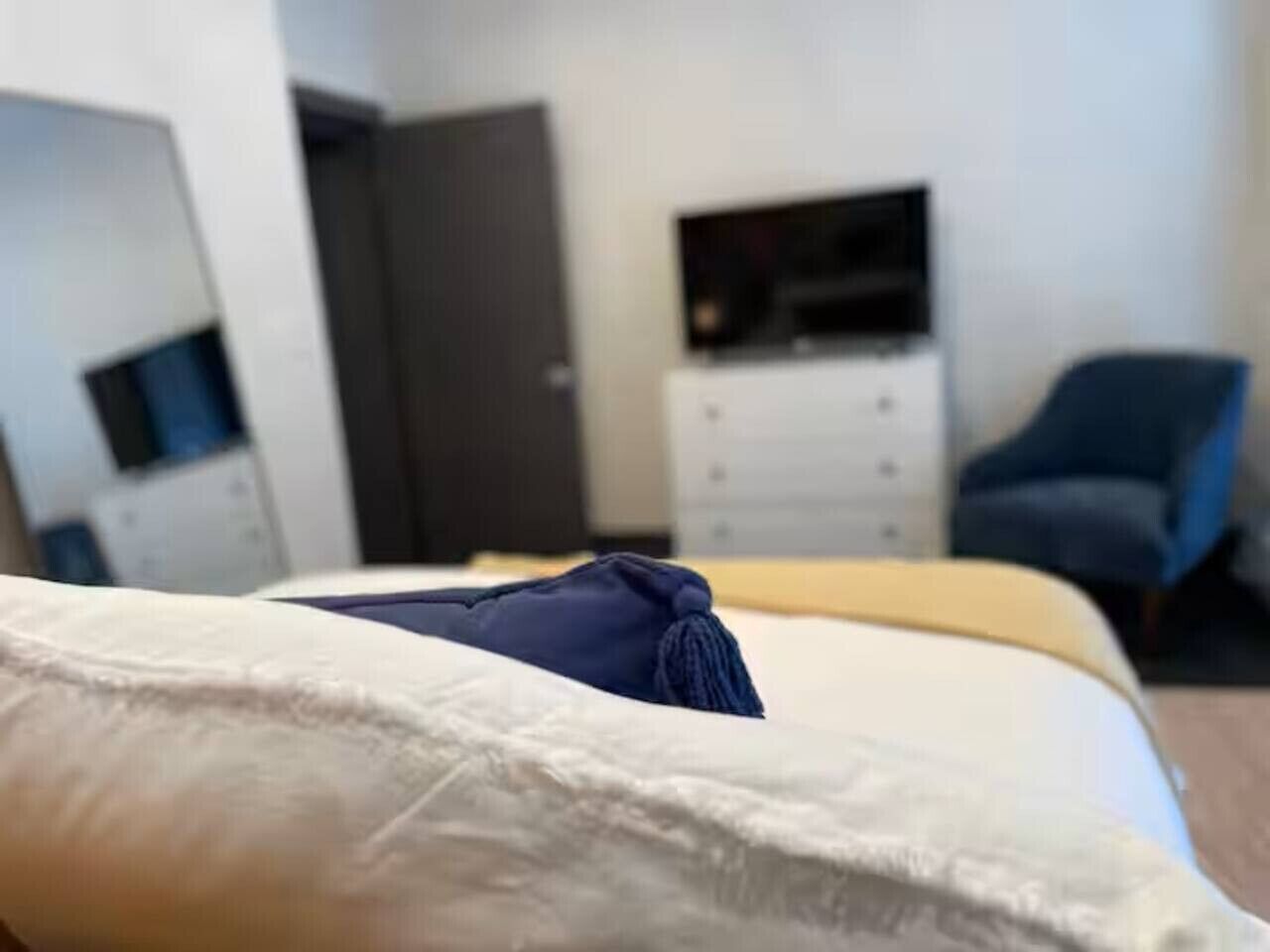 A hotel room with a bed, a television, a desk, and a chair.