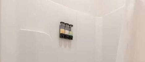A white bathtub with a towel, a shower curtain, and a soap dispenser mounted on the wall.