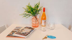 Una mesa con un libro, una botella, un vaso y un llavero.