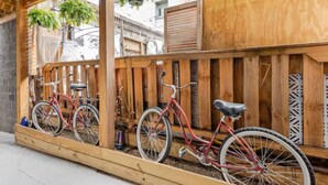 Un aparcaciclos de madera con dos bicicletas estacionadas.