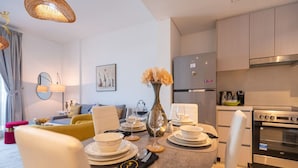 Una cocina moderna con comedor, un sofá y un jarrón con flores.
