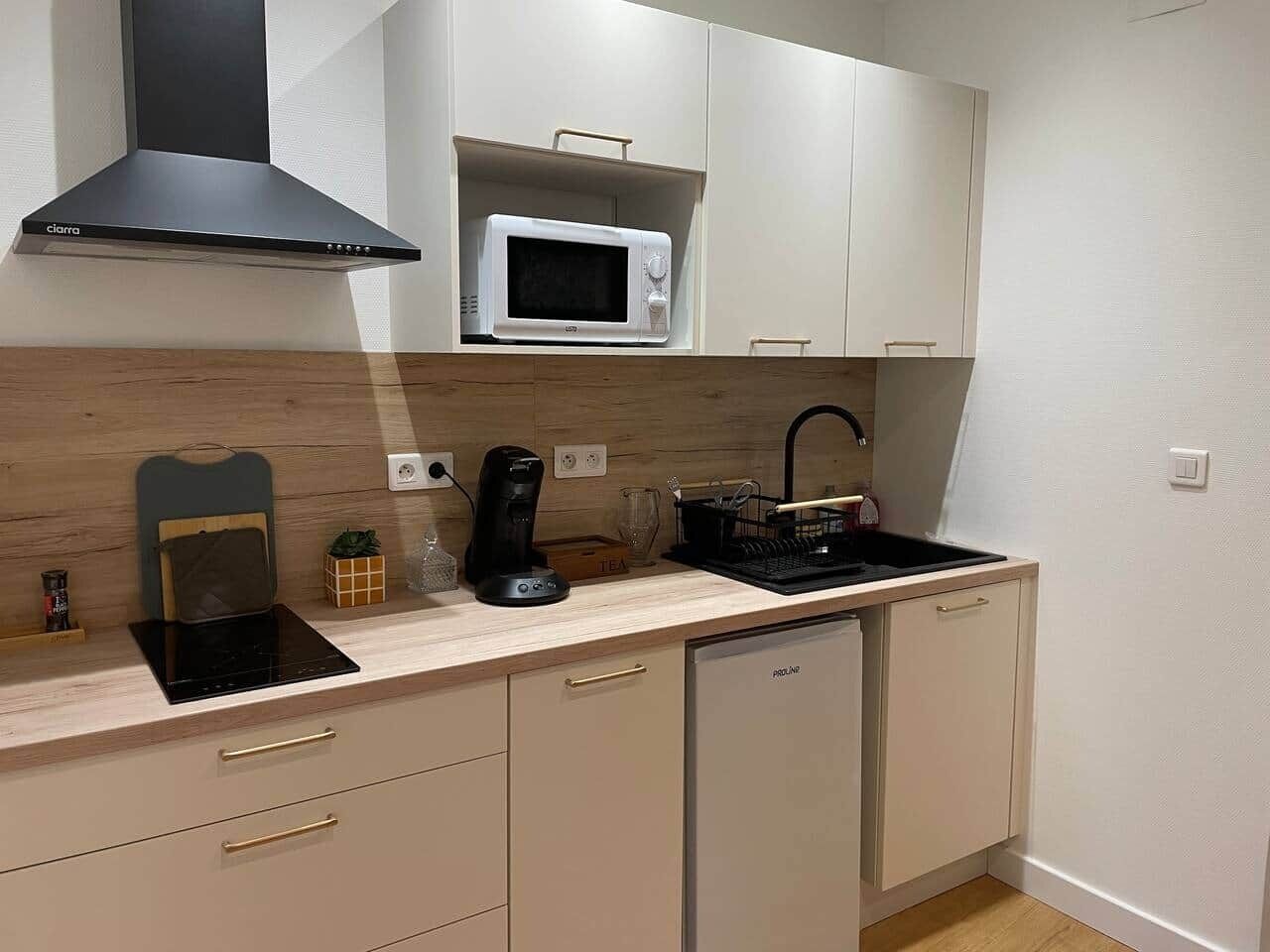 A compact kitchen with a microwave, coffee maker, and a dishwasher.