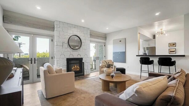 Una sala de estar moderna con chimenea, zona de estar y comedor con sillas.