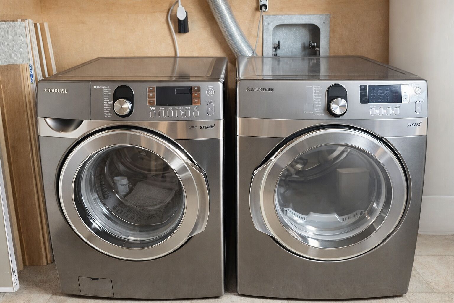 Two stainless steel Samsung washing machines with digital displays and control panels, placed side by side.