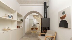 Een modern interieur met een open haard, zithoek en een trap naar een hoger niveau.
