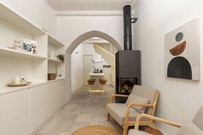 Ein modernes Interieur mit Kamin, Sitzecke und einer Treppe, die in ein Obergeschoss führt.