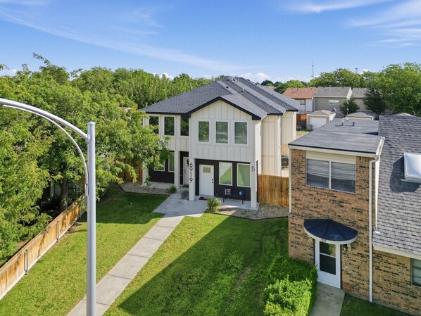 Ein Wohnhaus mit zweistöckigem Gebäude, sichtbarer Garage und gepflegtem Rasen.