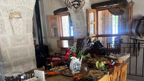 Un comedor rústico con pared de piedra, mesa de madera y sillas.