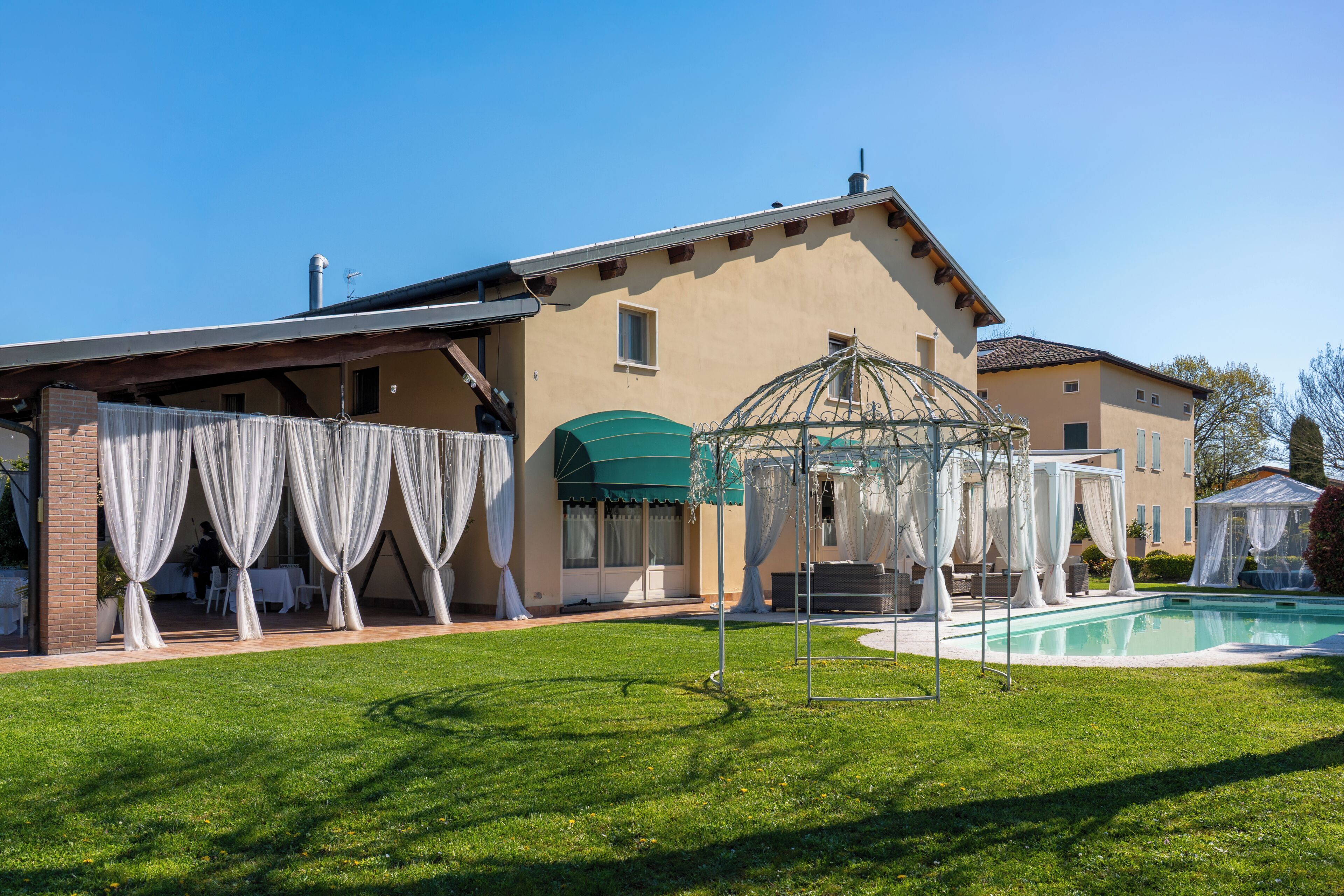 Ein Haus mit Swimmingpool, überdachter Außenbereich und großem Fenster.