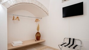 A bathroom with a wooden bench, a towel, a vase with pampas grass, and a black chair. - Trullo in Alberobello apartment for 4/6 people (Alberobello)