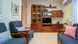 Un soggiorno con due divani, un mobile in legno e una televisione.