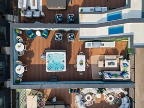 Une terrasse sur le toit équipée d’un jacuzzi, de coins salon et d’une piscine.