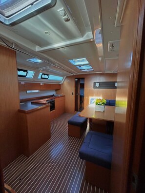 A compact galley with a kitchenette, a dining area with a table and bench, and skylights. - Sun-Kissed Sailing Adventure in Islas Sarónicas (Alimos)