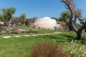 Un bâtiment surmonté d’un dôme, entouré d’un jardin bien entretenu, agrémenté de sentiers et d’arbres.