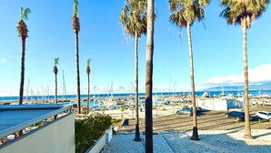 A marina with boats, palm trees, and a clear blue sky.