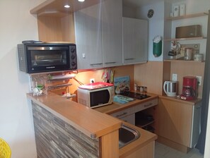 A compact kitchen with a microwave, toaster, and coffee maker. - Apartment 500m from the sea and 2min from Etel! (Erdeven)