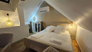 Een slaapkamer met een bed, bedlampjes, een airconditioning en uitzicht op de omgeving.