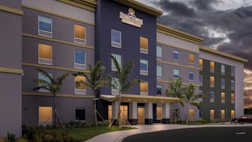 A modern hotel building with a flat roof, multiple windows, and a sign reading 'HOMETOWNNE STUDIOS.'