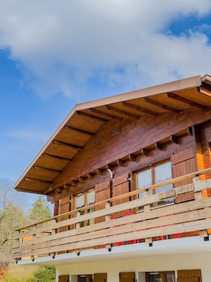Una cabaña de madera con balcón y un letrero que dice 'LE SKÉ CHALET'.