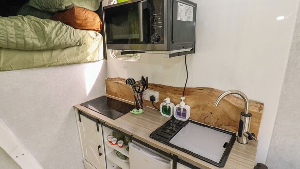 A compact kitchenette with a microwave, sink, and storage cabinets. - The Horse Box (Blaydon on Tyne)