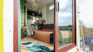 A room with a bed, a desk, a chair, a window, and a door. - The Horse Box (Blaydon on Tyne)