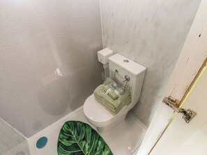 A bathroom with a toilet, a sink, and a green leaf-patterned mat. - The Horse Box (Blaydon on Tyne)