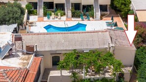A multi-story building with a swimming pool, outdoor seating, and a staircase leading to the upper levels. - The Orestis Cottage House , Stalos, Crete (Chania)