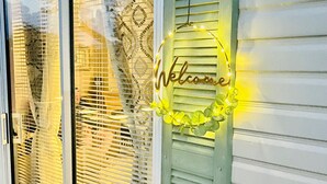 Een raam met een 'Welcome'-bord en decoratieve verlichting.