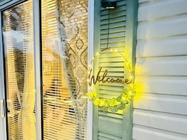 Una ventana con un letrero de 'Welcome' y luces decorativas.