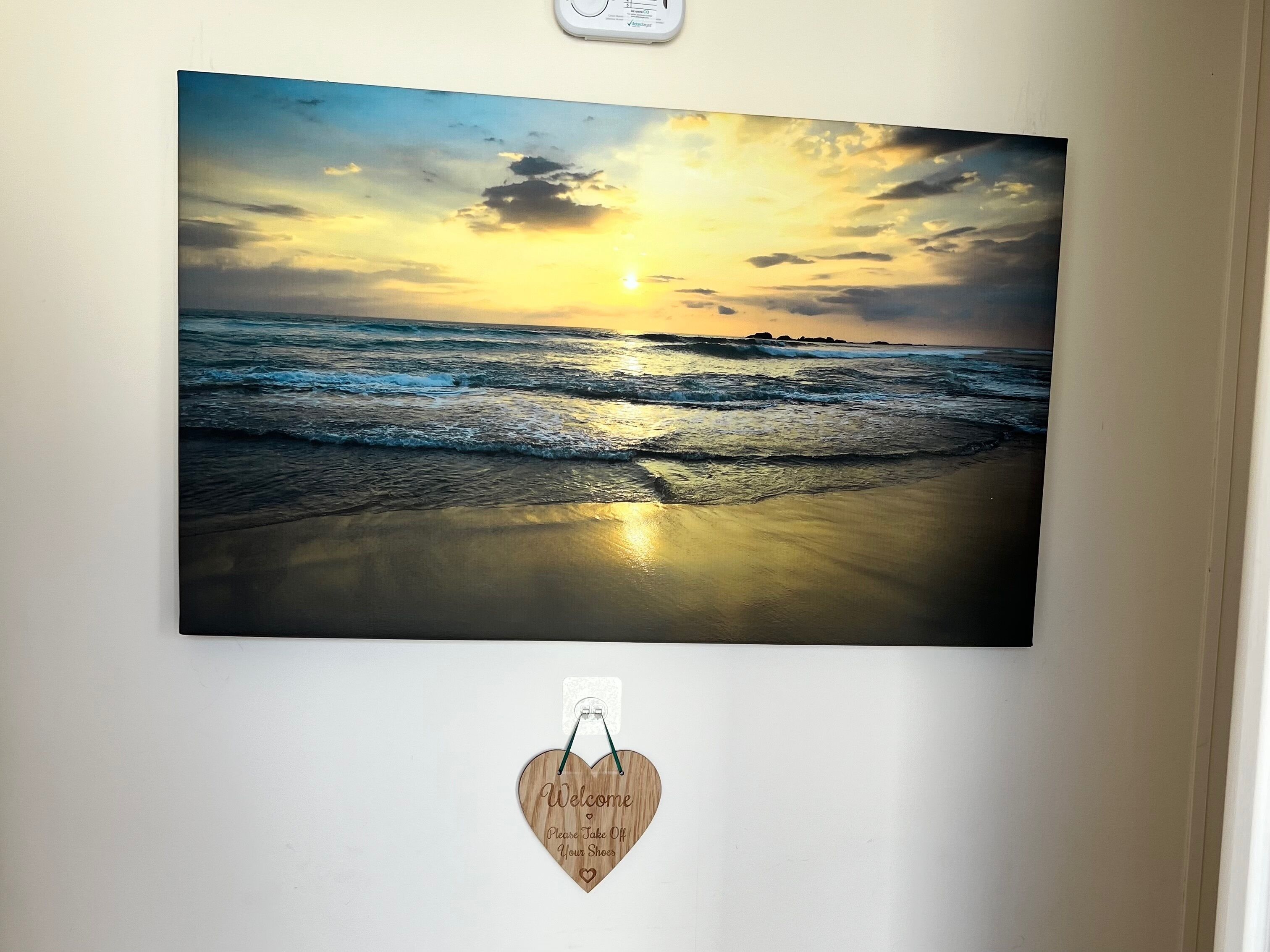 Et billede på væggen, der viser en solnedgang over havet.