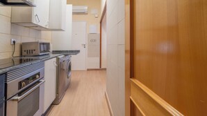 A compact kitchen with a microwave, oven, and washing machine. - Casita de San Juan in Cartagena, Murcia, Spain. (Cartagena)