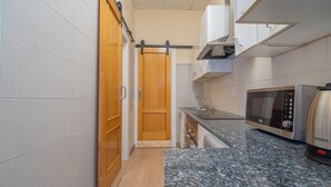 A kitchen with a sliding door, a microwave, and a stainless steel kettle. - Casita de San Juan in Cartagena, Murcia, Spain. (Cartagena)