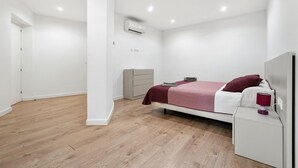 Ein modernes Schlafzimmer mit Bett, Nachttisch und Klimaanlage.