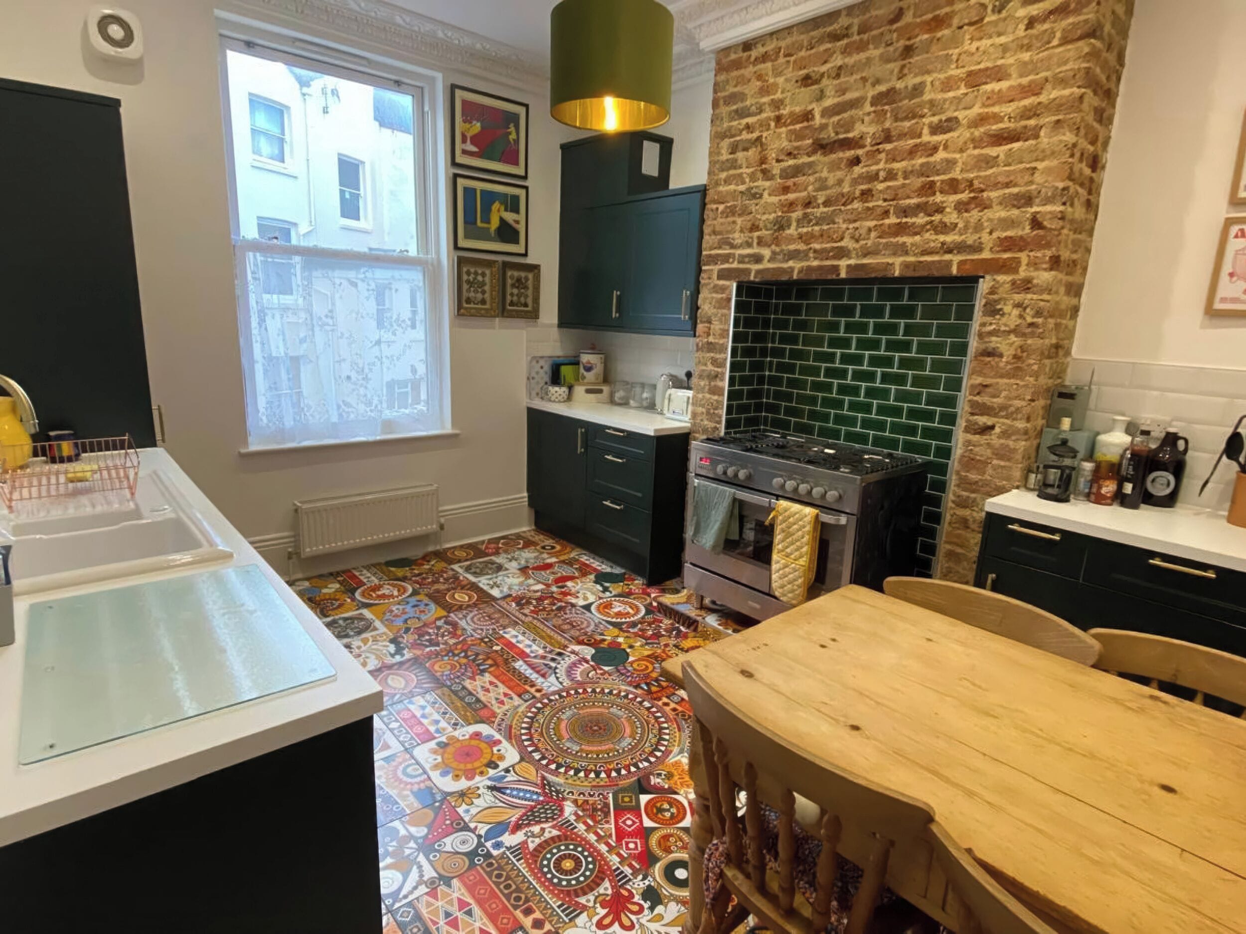 A kitchen with a patterned floor, a stove, and a brick wall.