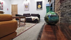 A living room with a sofa, a coffee table, a rug, and a large vase. - 21 Gensing Road (St Leonards-On-Sea)