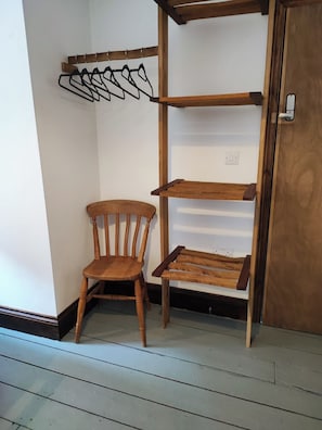 A corner with a wooden chair, a wooden shelf unit, and a coat rack. - The Courtyard Hideout (Hereford)