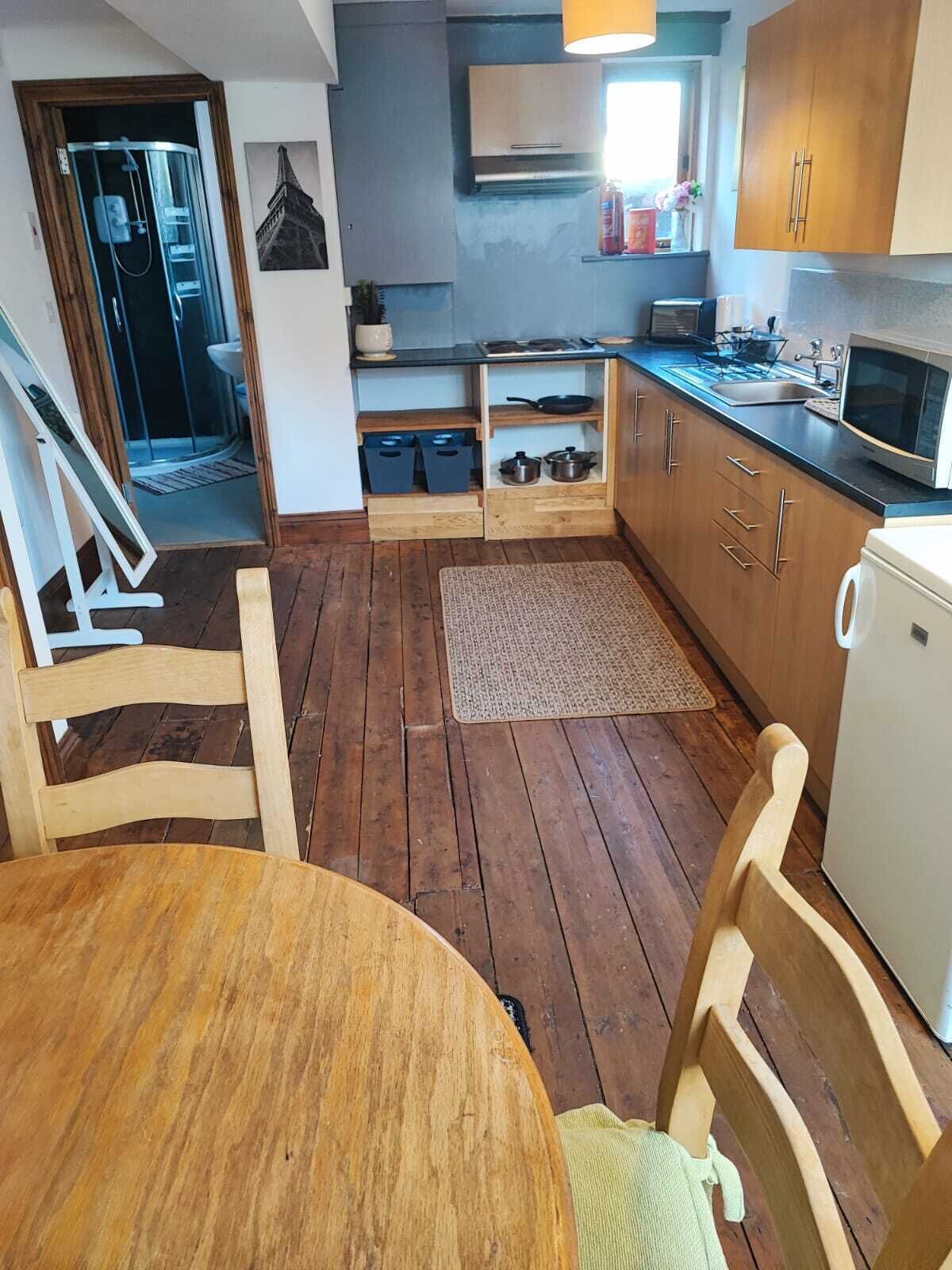 A compact kitchen with wooden cabinets, a microwave, and a sink.