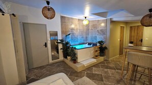 A modern bathroom with a bathtub, a mirror, and potted plants. - LA SUITE TILLEUIL (Montgé-en-Goële)