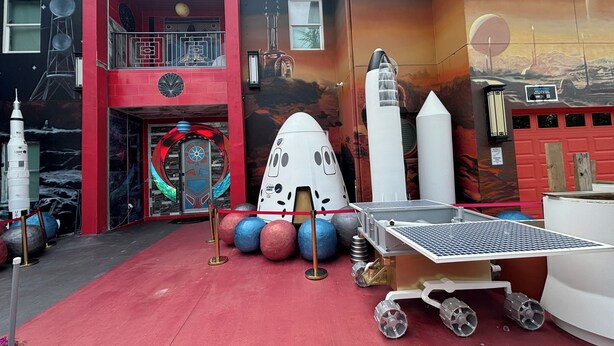 Un edificio con facciata rossa, un balcone e una porta con motivo circolare.