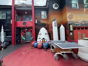 A building with a red exterior, a balcony, and a door with a circular design. - Mission to Mars (Davenport)