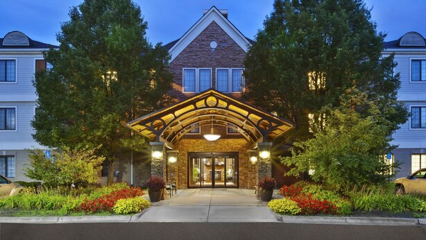 A two-story building with a stone facade, a gabled roof, and a central entrance with a decorative archway.
