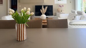 Un salon moderne comprenant un coin repas, un téléviseur à écran plat et une grande fenêtre.