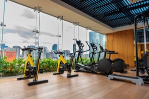 A gym with exercise equipment, large windows, and a city view. - OH | Amazing Loft Roma Nte w/ AC balcony & rooftop (Ciudad de México)