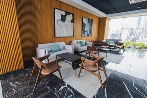 A modern lounge area with a sofa set, chairs, a coffee table, and artwork on the walls. - OH | Amazing Loft Roma Nte w/ AC balcony & rooftop (Ciudad de México)
