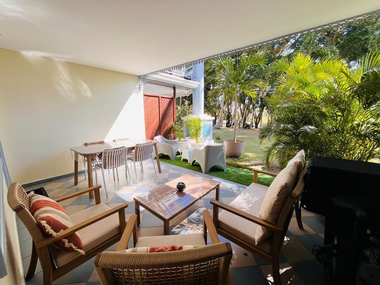 Un patio exterior con comedor, sillas y zona de barbacoa.