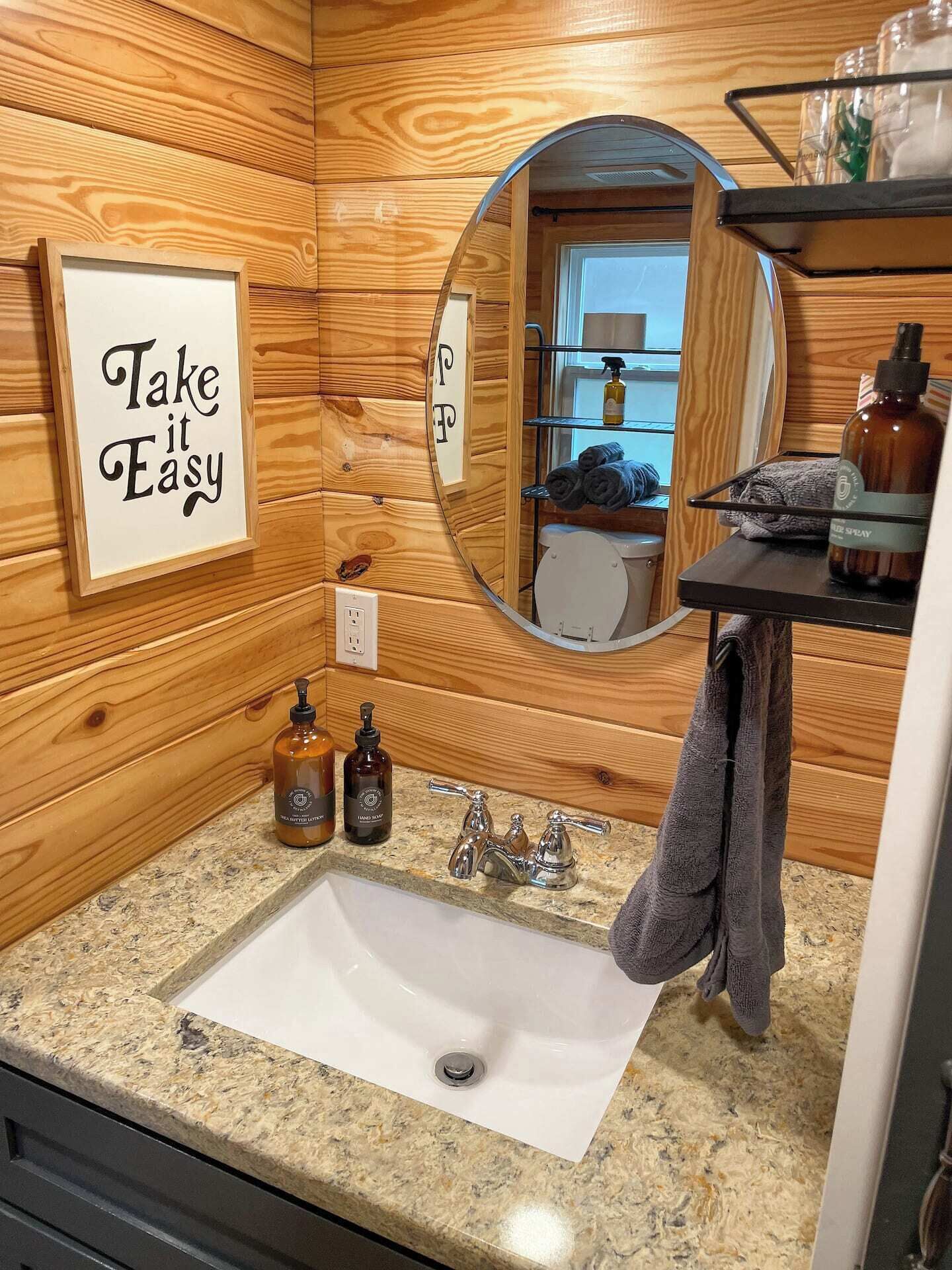 Un intérieur en bois comprenant un évier, un miroir et des articles de toilette.